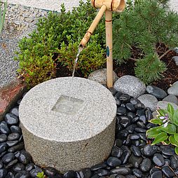 Kieselsteine umranden dieses Wasserspiel