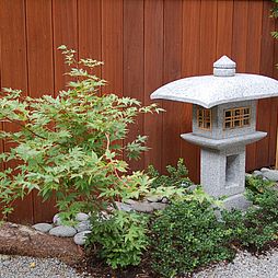 Eine Steinlaterne beleuchtet den hinteren Gartenteil