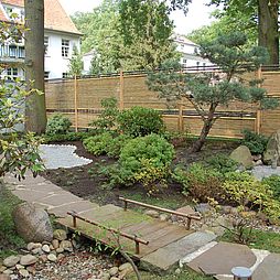 Der Weg in den Garten führt über eine Brücke