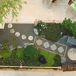 Bambustor, Kiesflächen und Wasserspiel im japanischen Garten