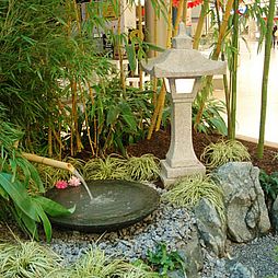 Granitlaterne und Wasserspeier im japanischen Garten